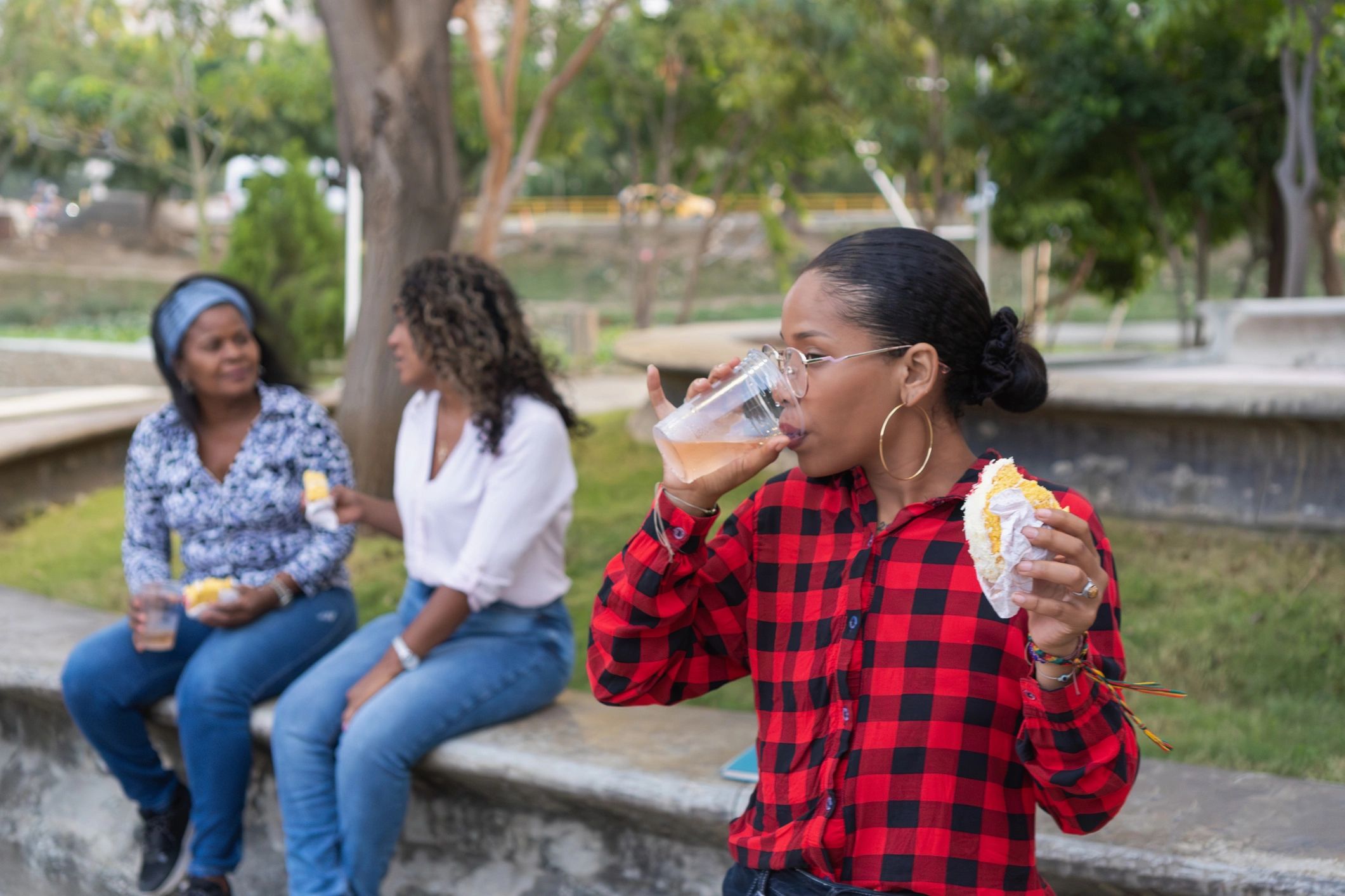 Friends sharing food and drinks outdoors in a park