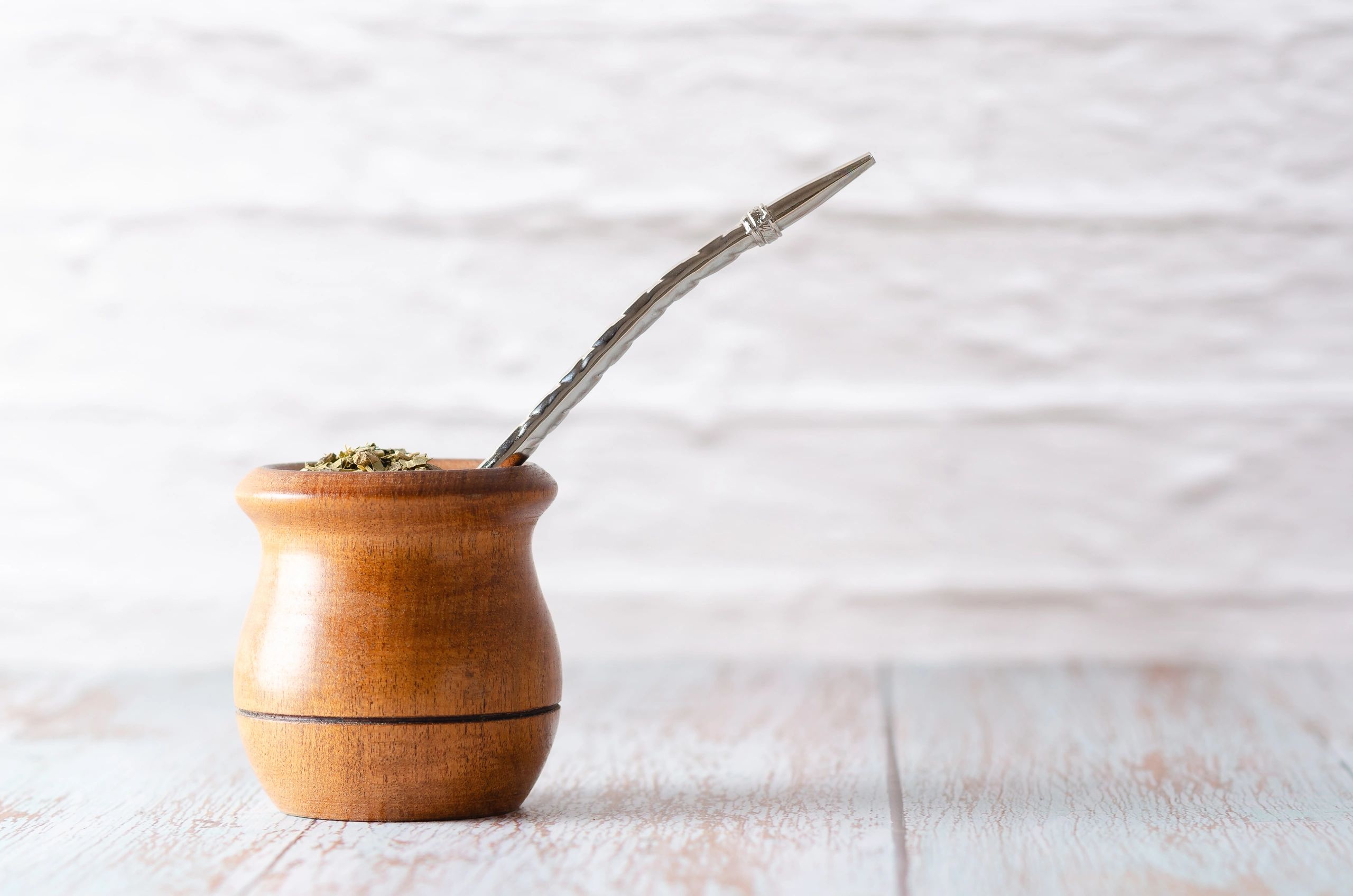 Wooden mate gourd with a metal bombilla straw